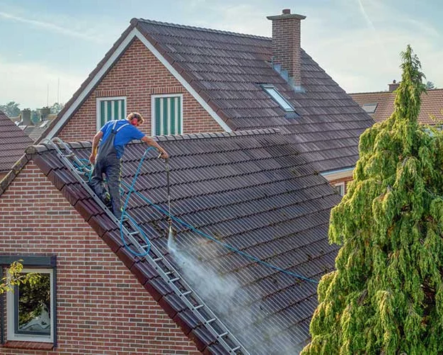 Dakdekker aan het werk op het pannendak van een woning