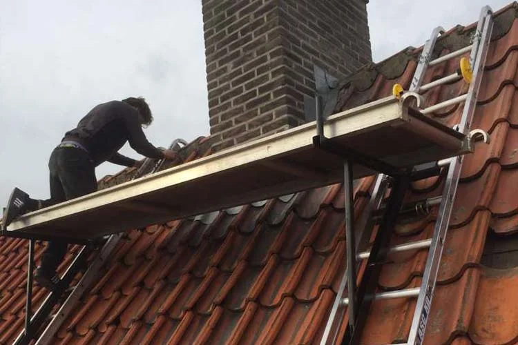 Dakrenovatie van een pannendak vanaf een dakgoot-steiger