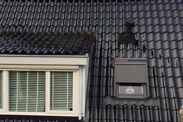 Pannendak met donkere dakpannen en een dakkapel