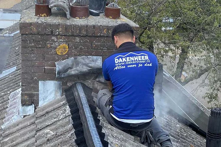 Dakdekker vernieuwt het loodwerk rond een schoorsteen