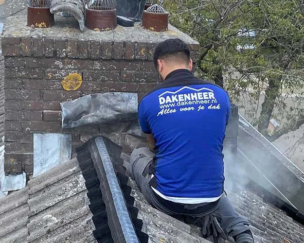 Dakdekker vernieuwt het loodwerk rond een schoorsteen